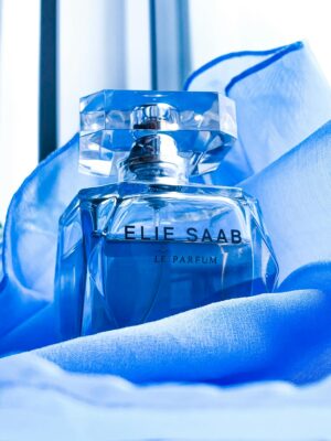 Luxurious Elie Saab perfume bottle displayed on soft blue silk fabric.